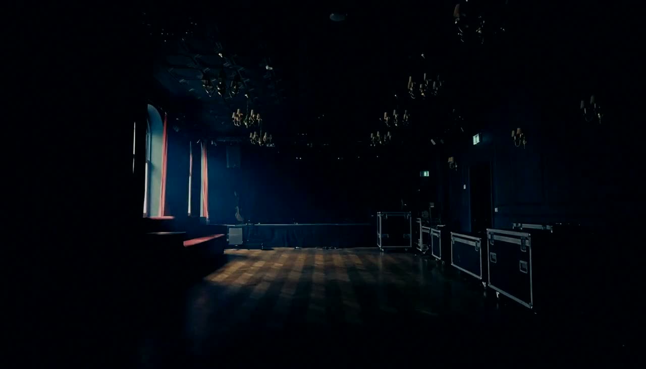 An empty venue as the lights come up, and equipment loaded into a van at dawn.